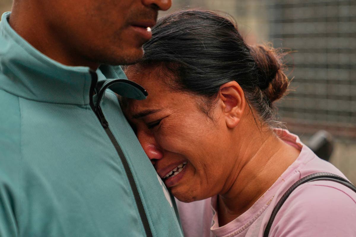 A relative consoles Sabina Dangal outside a government hospital on Friday as she waits for news of her brother, who is missing after flash floods, in Kathmandu, Nepal.