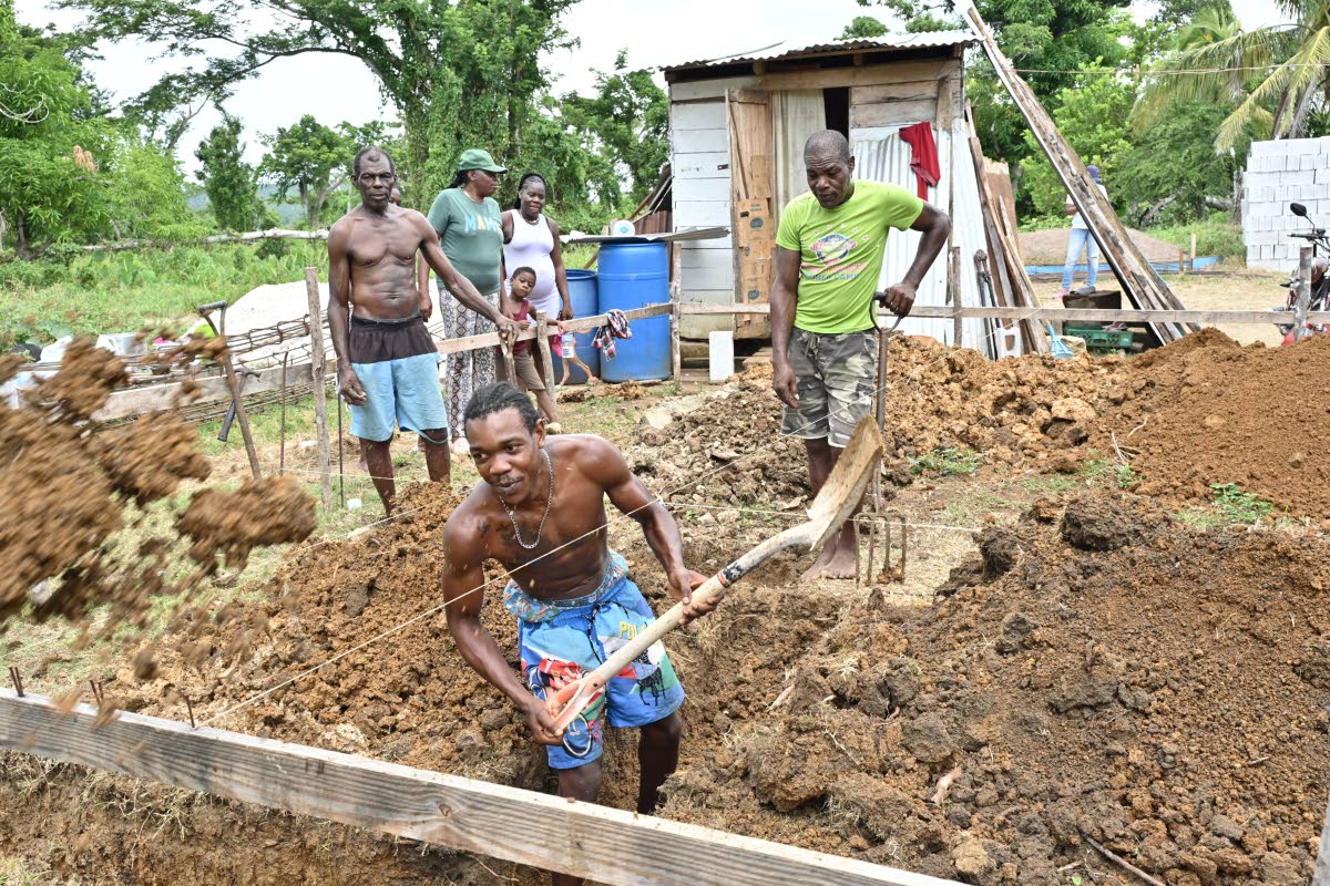 Mickey Robinson (left), grandson Davin Bennett (centre), and son Uion Robinson outine the home for the elderly Robinson couple in Galloway, Westmoreland, last Tuesday. The couple has been living in a shop (background) since the storm destroyed their home.