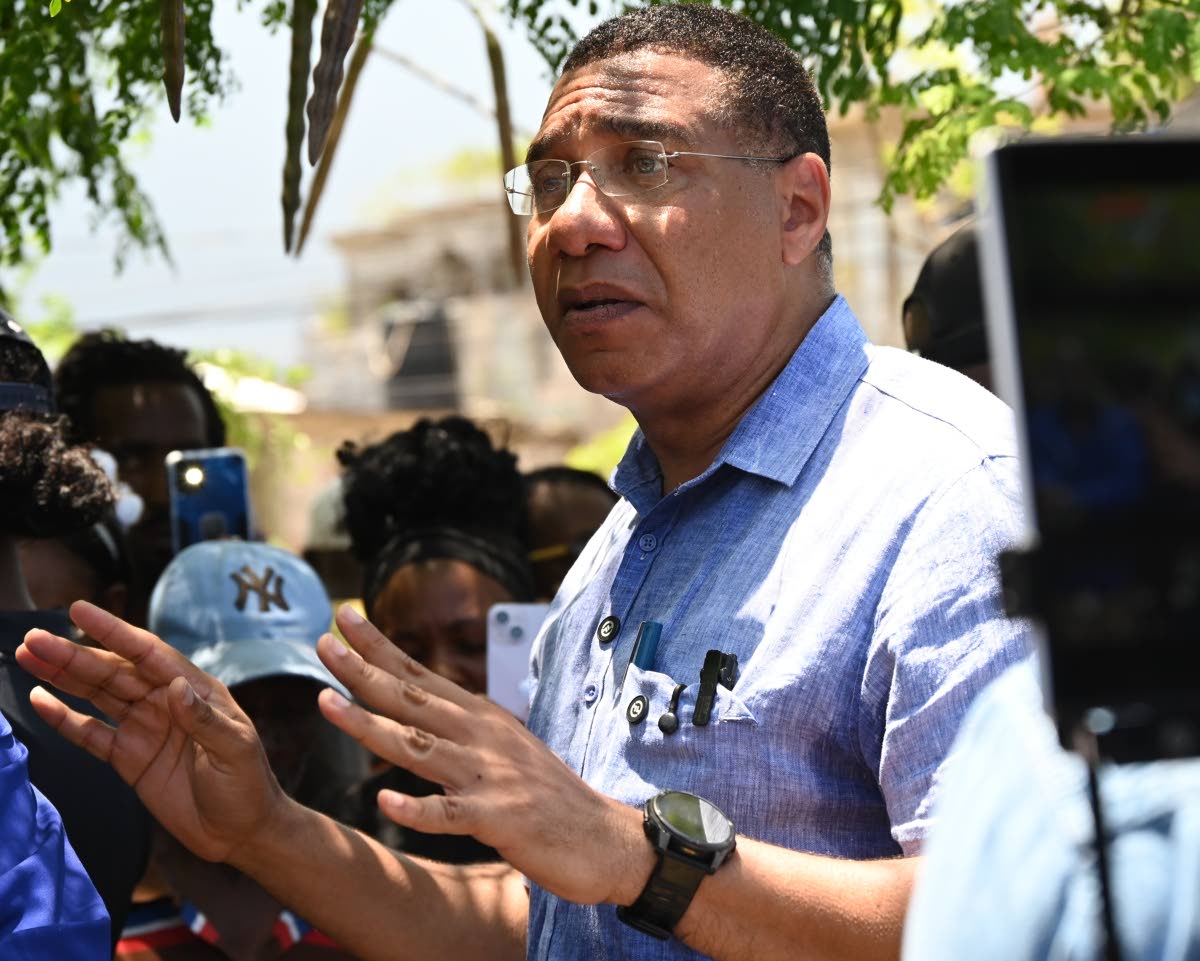 Prime Minister Dr Andrew Holness addresses residents during a tour in Coopers Pen, Trelawny, on Friday.