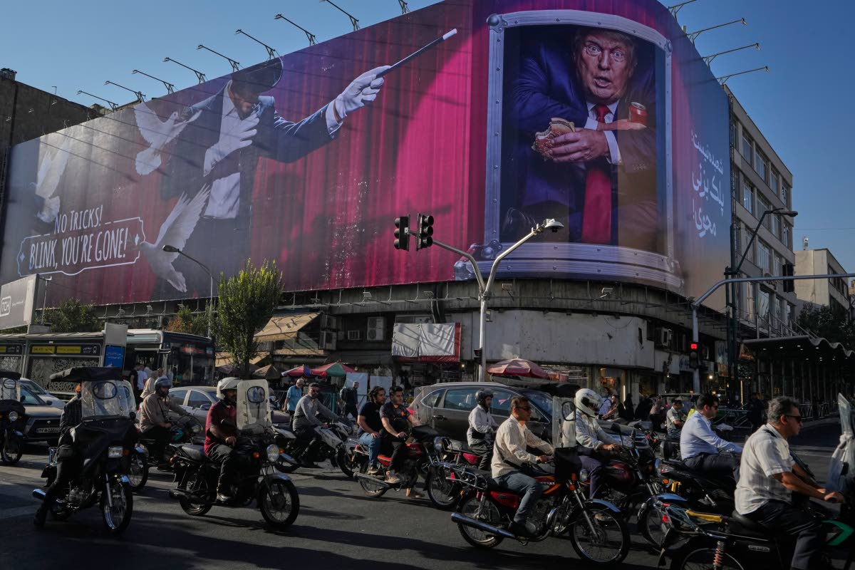 Motorcyclists ride past a billboard depicting U.S. President Donald Trump inside a catering container in downtown Tehran, Iran, Saturday, Aug. 29, 2026. 