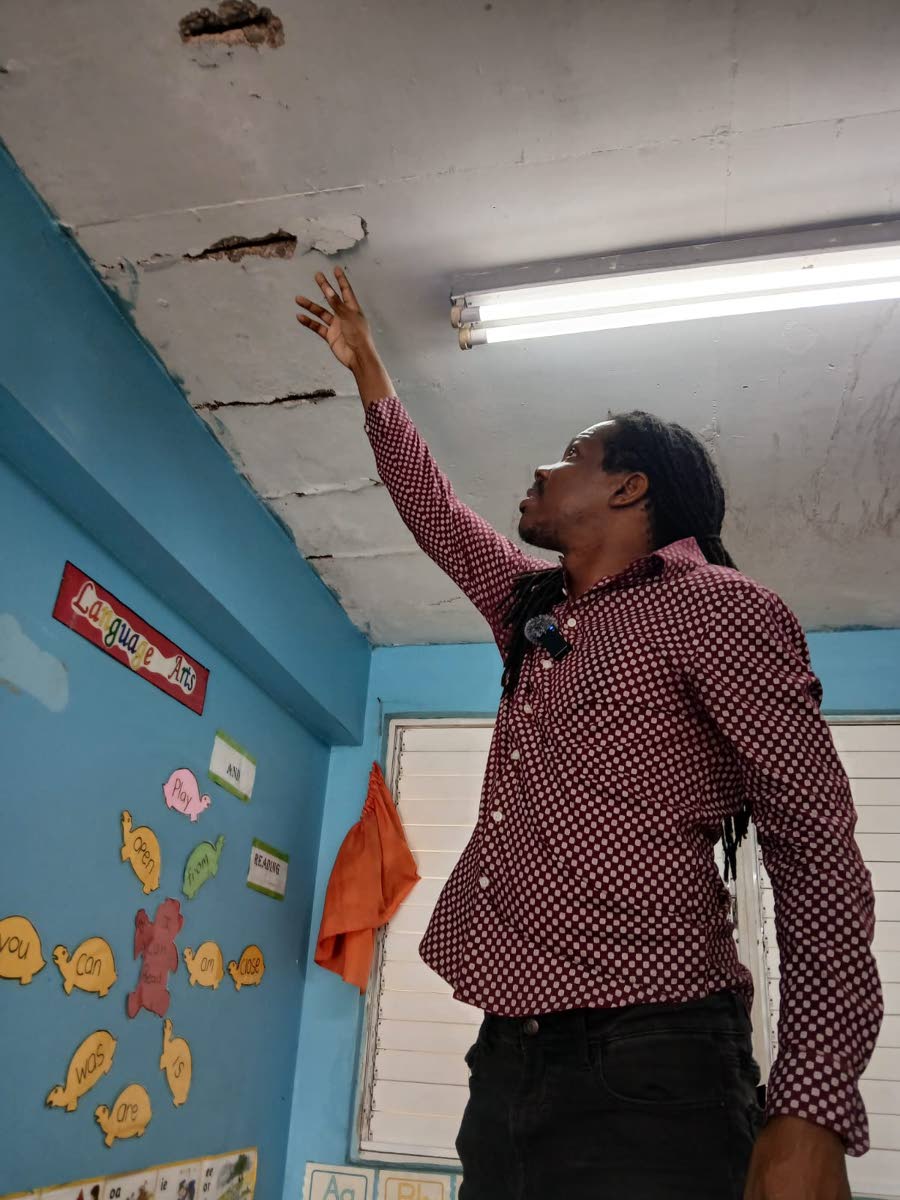 Opposition Spokesman on Education Damion Crawford examining a section of the Balcombe Drive Primary and Junior High School building yesterday.