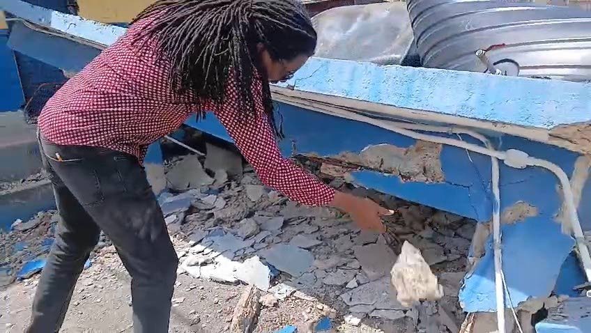 Opposition Spokesman on Education Damion Crawford examining a section of the Balcombe Drive Primary and Junior High  School building yesterday.