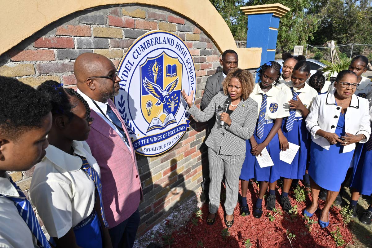 Education Minister Senator Dr Dana Morris Dixon (fourth left); Carlon Pitt (third left), principal of Hydel Cumberland High; and Dr Walton Small (behind Morris Dixon), retired principal of Hydel High, unveiling the name of the merged school on Monday as St