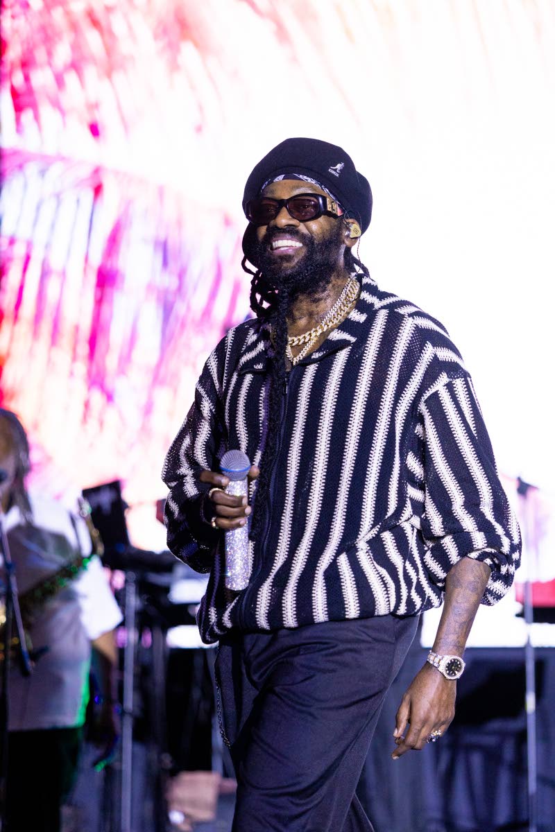 Headline performer Tarrus Riley cuts a stylish figure in a black-and-white vertically striped shirt, paired with dark trousers and accessorised with jewellery and shades.