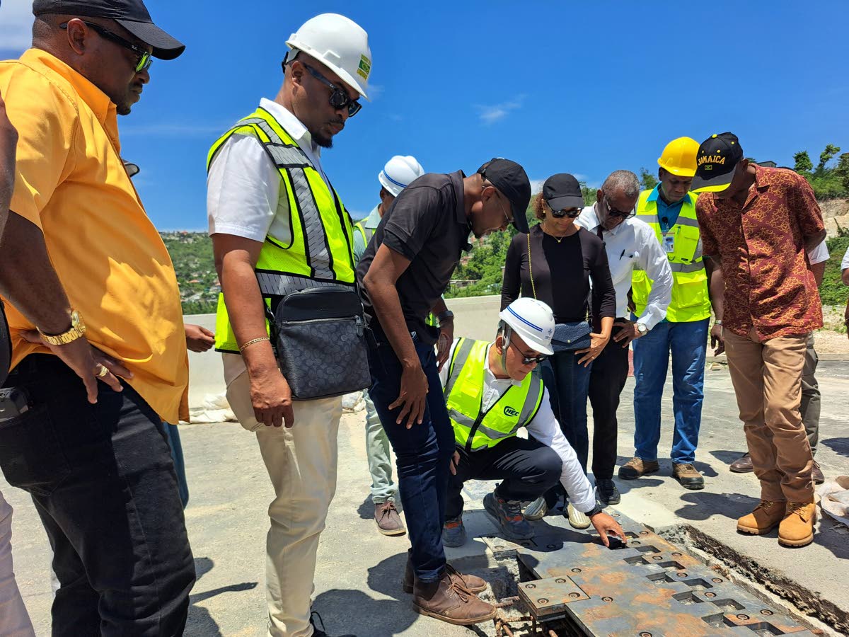 Works Minister Robert Morgan (third left) looks on as Gui Hongsheng (fourth left), project manager from China Harbour Engineering Company, showcases a section of the Montego Bay Bypass which is still under construction, during a tour of the bypass and othe