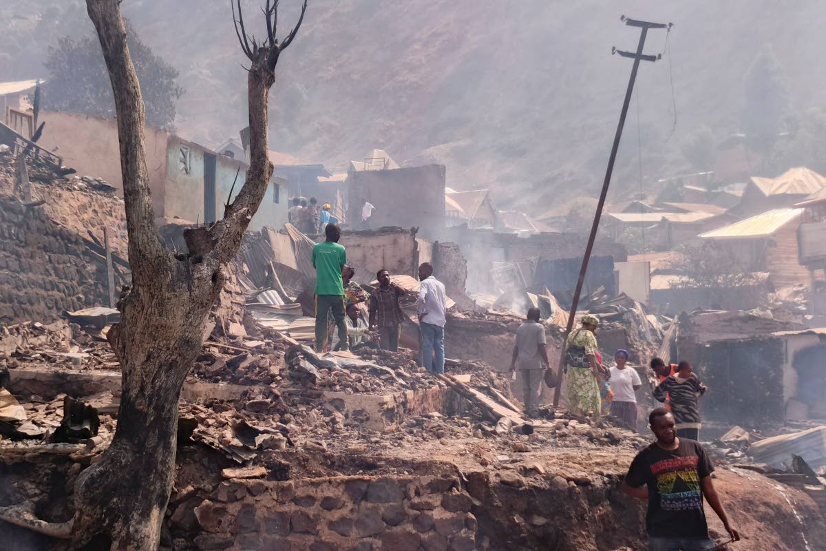 People walk through smoke after a fire at a school killed several people in Bukavu, Congo, Thursday, Sept. 10, 2026. (AP Photo/Janvier Barhahiga)