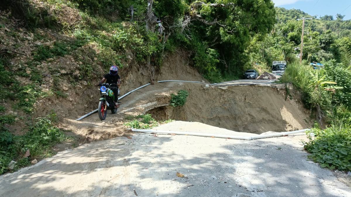  A motorcyclist navigates a section of the Spring Mount main road in St James, where a breakaway caused by rushing water during heavy rainfall during the passage of Hurricane Melissa is disrupting rural life.