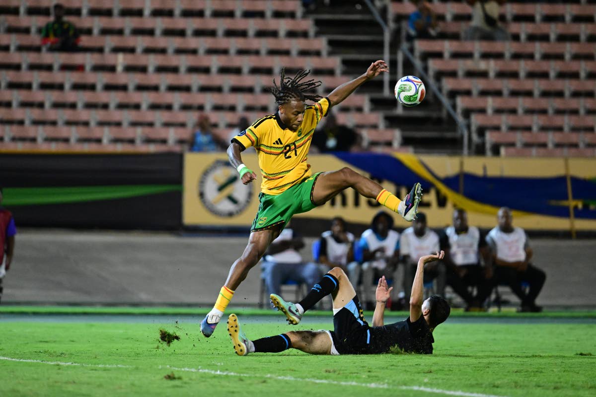 
Reggae Boy Rumarn Burrell hurdles a challenge during a Concacaf Nations League football match against Guatemala at the National Stadium on Friday night.