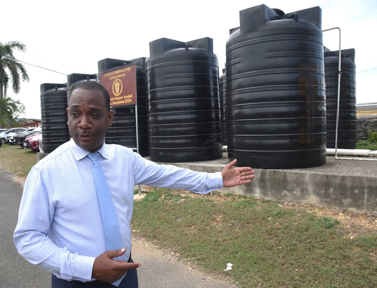 Anthony Garwood, principal of Dinthill Technical High School, displays water tanks donated by the school's past-student association.