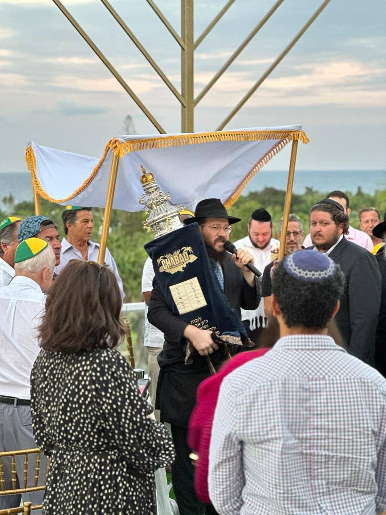  
Rabbi Yaakov Raskin joins the singing and dancing during the traditional procession welcoming a newly handwritten Torah scroll to Chabad of Jamaica.