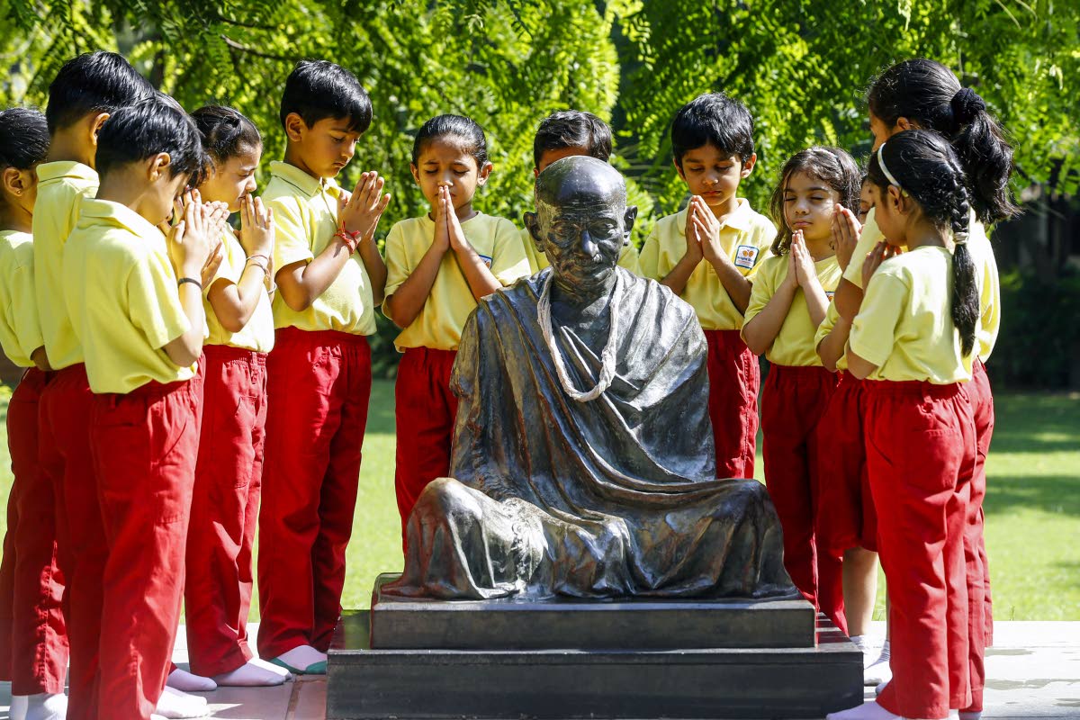 Students pay homage to the statue of Mahatma Gandhi on the eve of Mahatma Gandhi Jayanti observed on October 2 during their visit to the Gandhi Ashram, in the western Indian city of Ahmedabad.