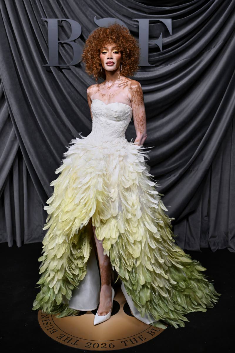 Jamaican-Canadian model Winnie Harlow makes a statement in a Nicole + Felicia dress featuring a sculpted ivory corset and a striking cream-to-green gradient of hand-placed feathers..