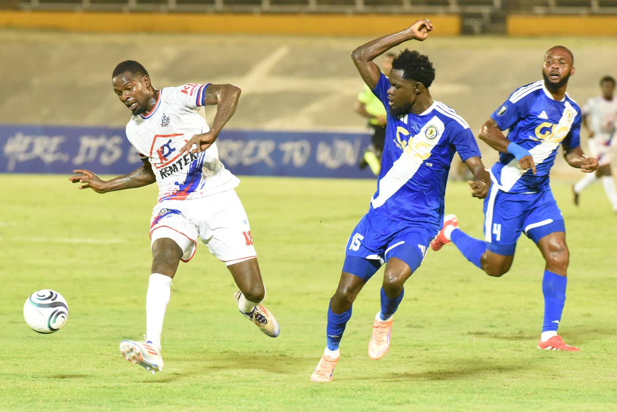 Corey Burke (left) from Portmore United, tries to get the better of Kyle Ming (centre) and Fitzroy Cummings from Mount Pleasant FA during their Concacaf Caribbean Cup match at the National Stadium. 