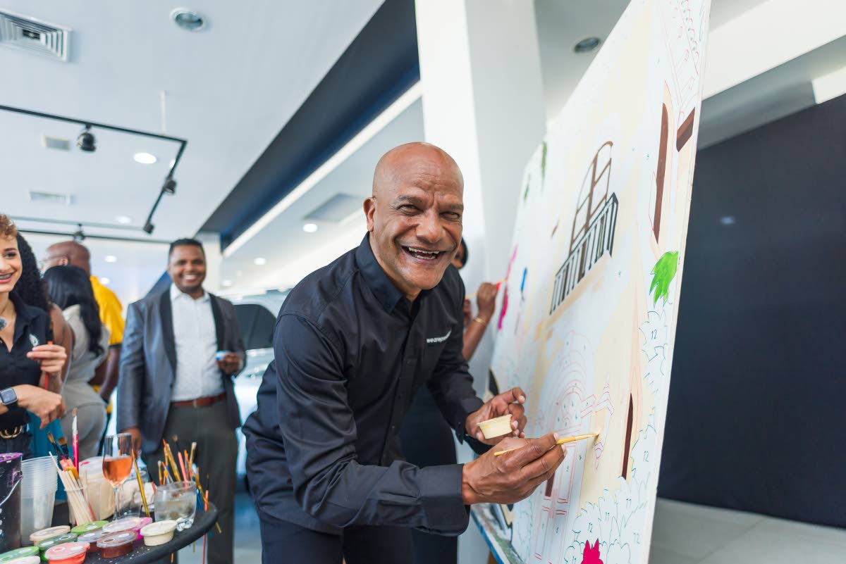 Peter Bunting tries his hand at painting during the live art installation in the Mercedes-Benz showroom.