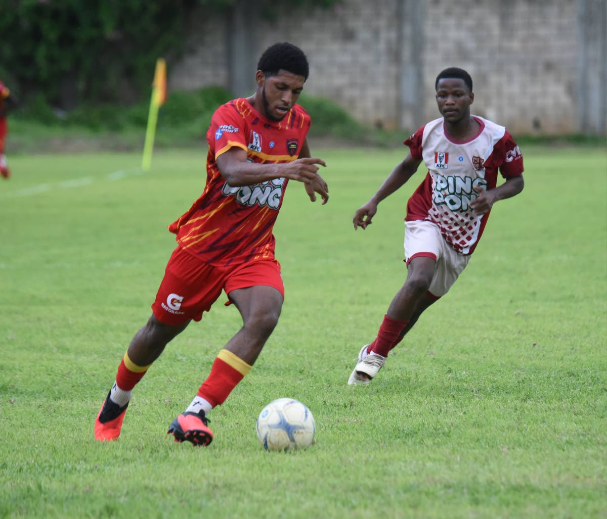 Cornwall College’s Khalid Fraser (left) outruns St James High’s Deyon Bailey during their ISSA daCosta Cup football match at Cornwall College yesterday.