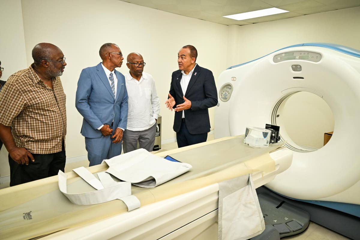Minister of Health and Wellness, Dr Christopher Tufton (right), makes a point while touring the radiography department of the Tensie Mae Robinson (TMR) Medical Limited, following the ceremony for the official opening of the healthcare facility in Portmore,