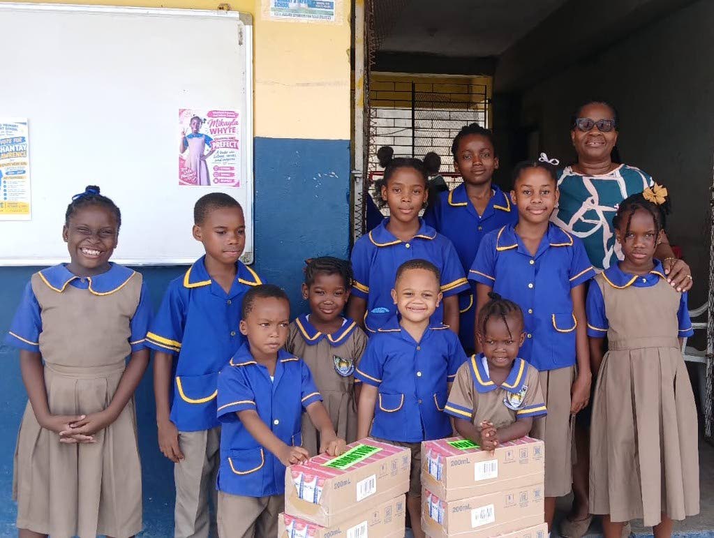 Diana Taffe-Myrie, principal of Whitfield Primary and Infant School, shares a moment with students following the first delivery of Nutri+ Milk. The school is set to receive 2,400 units of milk throughout the 2026/2027 academic year, as part of Seprod’s o