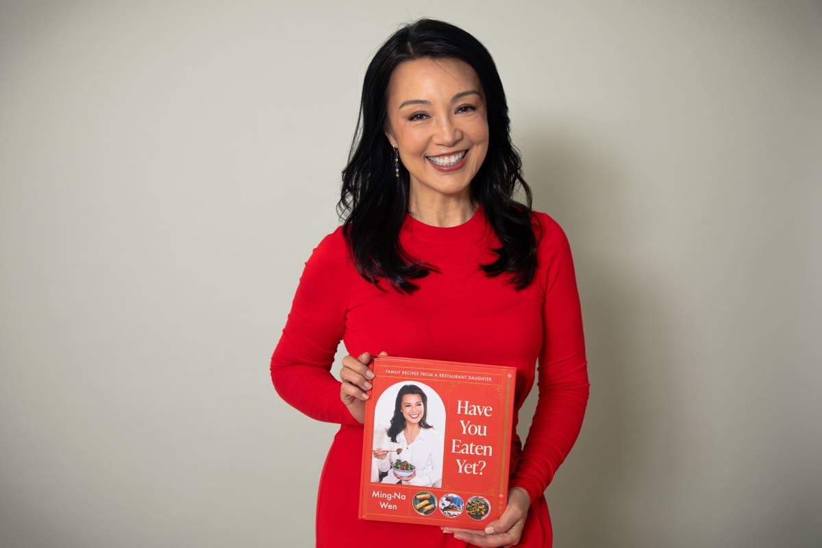 Ming-Na Wen poses with the cookbook ‘Have You Eaten Yet? Family Recipes From a Restaurant Daughter’. 