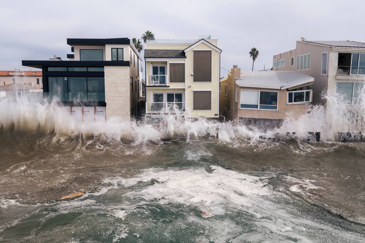 In an aerial view, waves crash into beachfront homes during high tide and storm surge from Tropical Storm Rachel, Saturday, October 10, 2026, in Long Beach, California. (Stephen Lam/San Francisco Chronicle via AP)