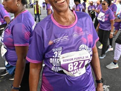 Judith Wedderburn, board member of Women’s Media Watch, smiles for the camera after participating in the Senior 3K Purple Run/Walk.