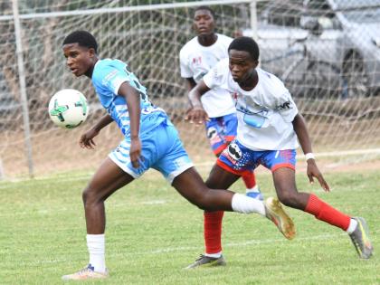 Ryland Fray-Campbell (left) of St George’s College moves away from Oniel Nelson of Holy Trinity during their Manning Cup Zone A match at Winchester Park yesterday. St George’s won 3-1.