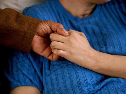 This image provided by News21 shows Junior Clase and his wife, Solibel Olaverria, holding hands on Sunday, June 22, 2025, at Olaverria's rehabilitation facility in Allentown, Pa. (Jessica Sachs/News21 via AP)
