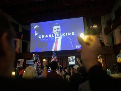 People hold candles and sing during a memorial and prayer vigil for Charlie Kirk at the John F. Kennedy Memorial Center for the Performing Arts in Washington DC. 
