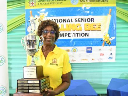 Champion speller Beverly Been happily poses with the winner’s trophy.