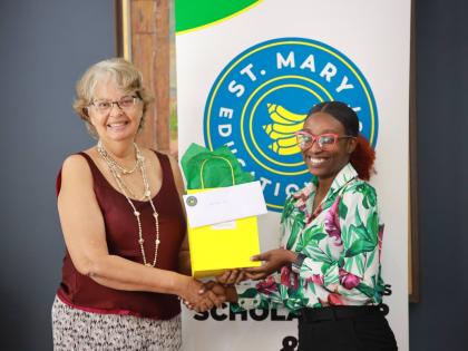 Ernest Johnston Memorial Bursary (EJMB) recipient, Nevena Jones (right), receives a congratulatory token from Patricia Francis, representing the EJMB at the 2025  St Mary Education Trust Awards Ceremony.