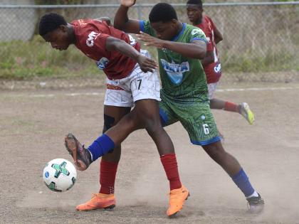 Antonio Fearon (left) of Eltham High shields the ball from Norman Manley High’s Nickoy Davidson during their Manning Cup football match at Norman Manley yesterday. The game was abandoned after 64 minutes due to heavy rain and lightning, with Eltham leadi