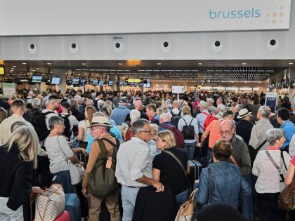 People stand in a line to check in after a cyberattack caused delays at Brussels International Airport in Zaventem, Belgium, Saturday, September 20, 2025. (AP Photo/Harry Nakos)