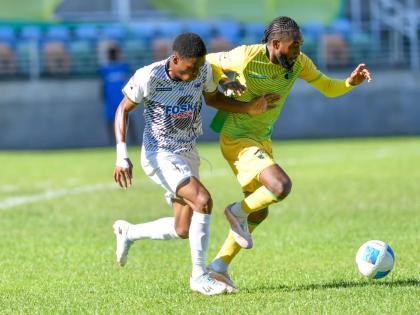 Kevoan McGregor (left) of Cavalier fights to gain possession of the ball from Jhanni Flemmings of Treasure Beach during their Jamaica Premier Leage match  at Sabina Park yesterday. Cavalier won 2-1. 