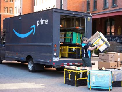 An Amazon Prime driver makes a delivery outside an apartment building.