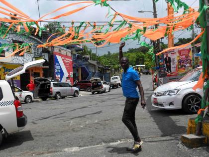 In this June 26, 2025 photo, a man walks through a cluttered Gayle square in St Mary.