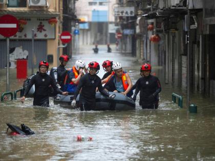 In this photo released by Xinhua News Agency, members from the local customs authority help stranded citizens to evacuate from an inundated street as Super typhoon Ragasa passed nearby Macao in southern China, September 24, 2025. (Cheong Kam Ka/Xinhua via 