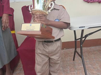 Winner of the Kiwanis Club spelling competition posing with his trophy.