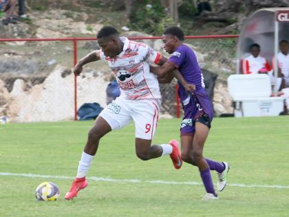 Orane Watson (left) of Glenmuir High powers past Bustamante High’s Omario Brissettt in a daCosta Cup match on September 10.  
Hosts Glenmuir won 13-0 with Watson scoring eight times. 