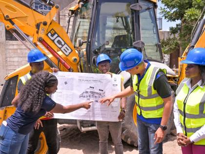 Prime Minister Dr Andrew Holness (second right), is shown the plan for the ‘Village at Tower Hill’ development by Roni-Kaye McLaren, architectural designer, during the contract signing and ground breaking ceremony at the project site on June 13.