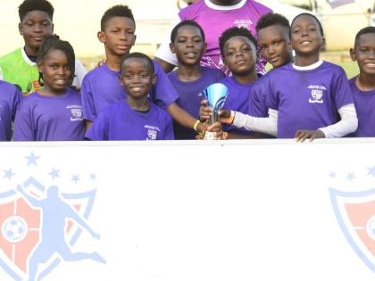 St Peter and Paul under-11 team celebrates winning the Youth Football League’s Junior Cup Urban Championship at the Constant Spring Field on Saturday. 