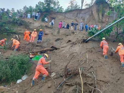 In this handout photo released by the National Disaster Response Force (NDRF), NDRF personnel look for survivors after debris from a massive landslide hit a passenger bus Tuesday night, near Bilaspur in India's northern state of Himachal Pradesh, Wednesday