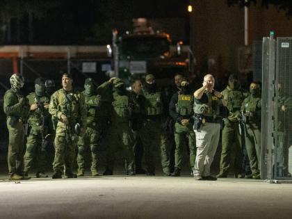 Federal law enforcement officers stand guard in the open gate of the fence built on Beach Street outside the Broadview ICE processing facility in suburban Broadview, Tuesday, October 14, 2025. (Tyler Pasciak LaRiviere/Chicago Sun-Times via AP)