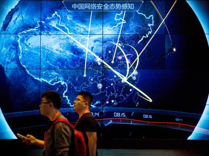 Attendees walk past an electronic display showing recent cyberattacks in China at the China Internet Security Conference in Beijing.