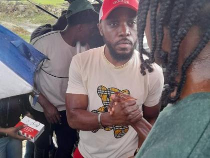 Kevin Downswell (left) shares a moment with a resident of a hurricane-ravaged community during a recent relief tour.