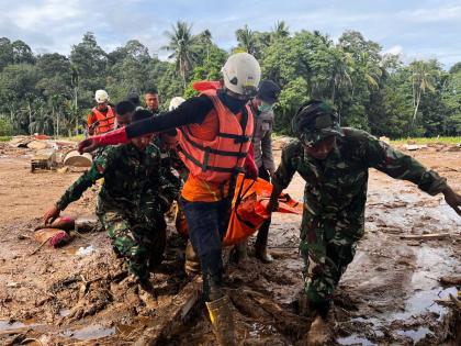 Rescuers carry the body of a flood victim in Agam, West Sumatra, Indonesia.