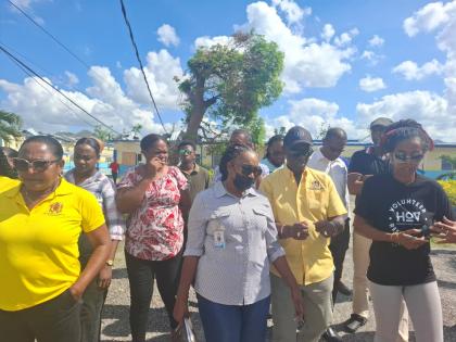 Local Government Minister Desmond McKenzie and a team are joins by residents during a visit to the Petersfield High School shelter in Westmoreland on Tuesday.