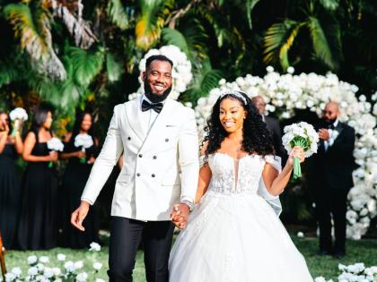 The newlyweds beam with joy as they make their first walk up the aisle together.
