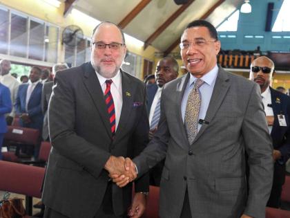Prime Minister Dr Andrew Holness (right) and Opposition Leader Mark Golding share a moment at the 46th Annual National Leadership Prayer Breakfast held at Boulevard Baptist Church in St Andrew on Thursday.