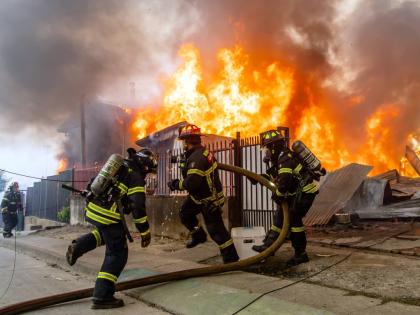Firefighters battle a blaze at a house as wildfires burn in Lirquen, Chile.