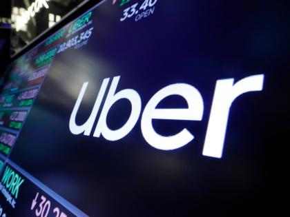 The Uber logo appears above a trading post on the floor of the New York Stock Exchange, August 16, 2019. (AP Photo/Richard Drew, File)