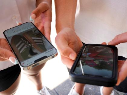 Young people use their phones to view social media in Sydney, Australia.